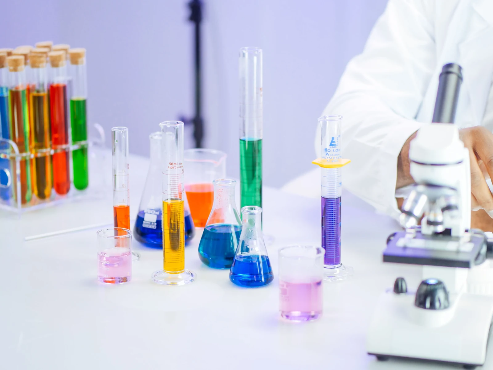 Microscopio y matraces con líquidos de colores preparados para un experimento de ciencias